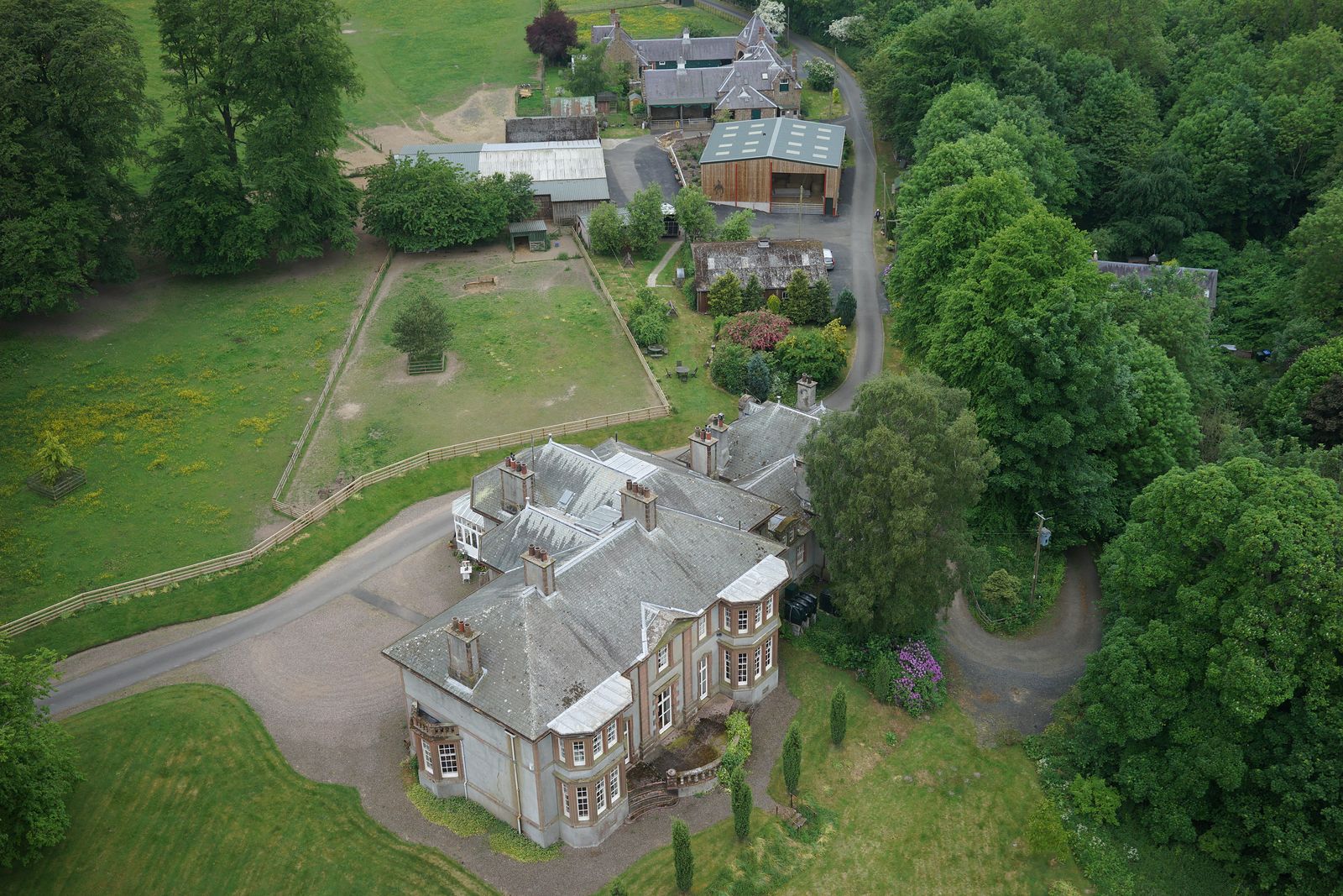Aerial view of a large house in its grounds with the building, parking, fire access route, assembly point and roof issues marked