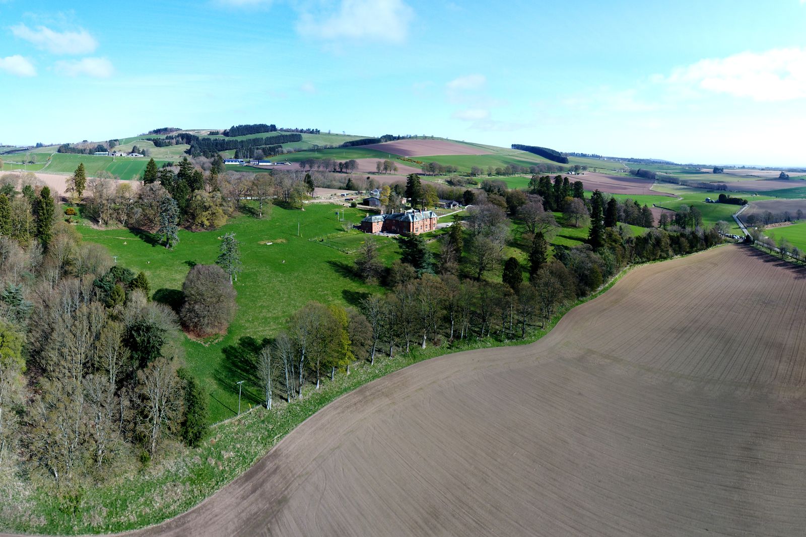 Aerial view of a country estate with the boundary, woodland, parkland and an arable field marked as a map overlay
