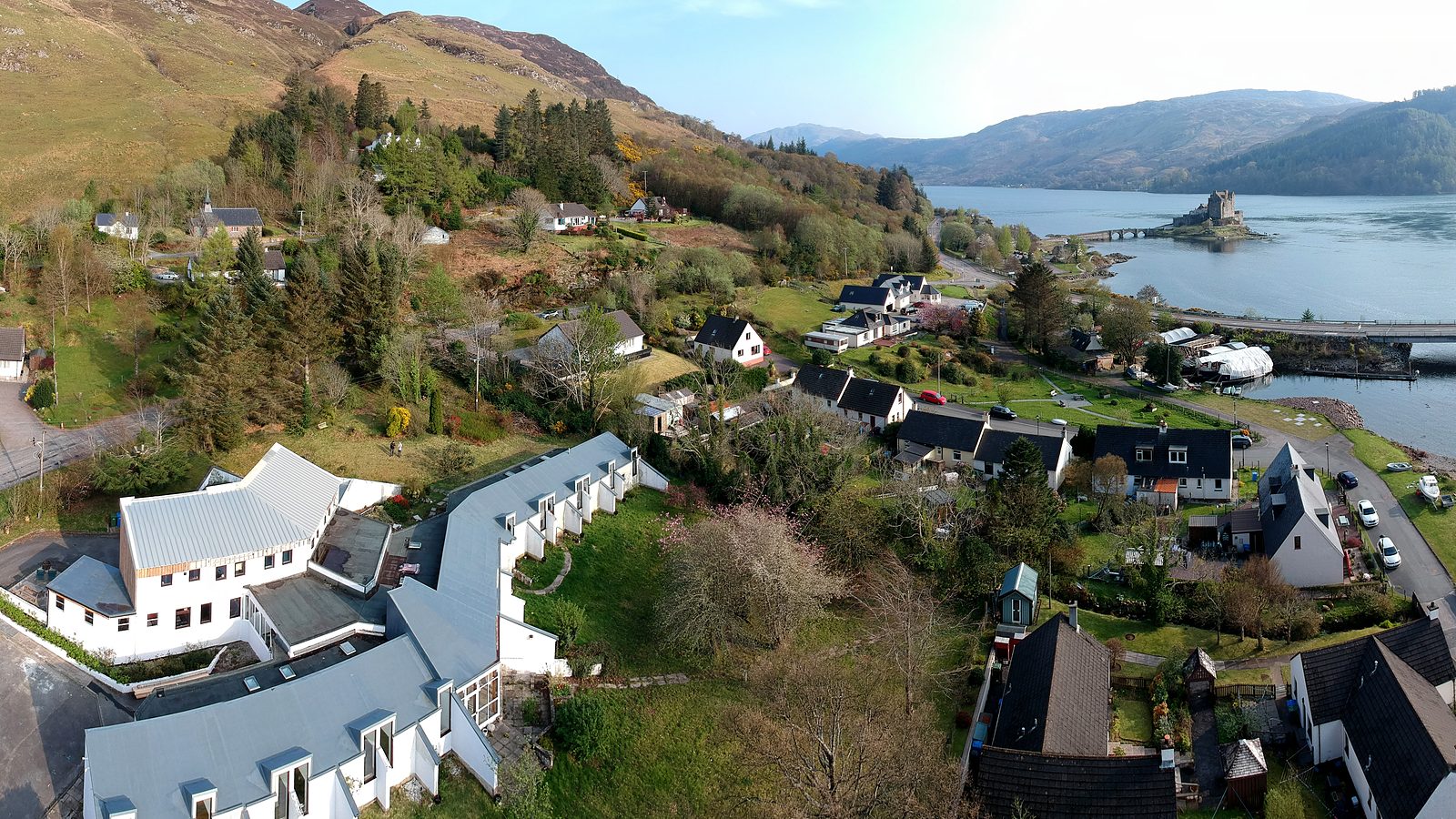 Aerial view over Dornie village and Loch Duich with Eilean Donan Castle on its island